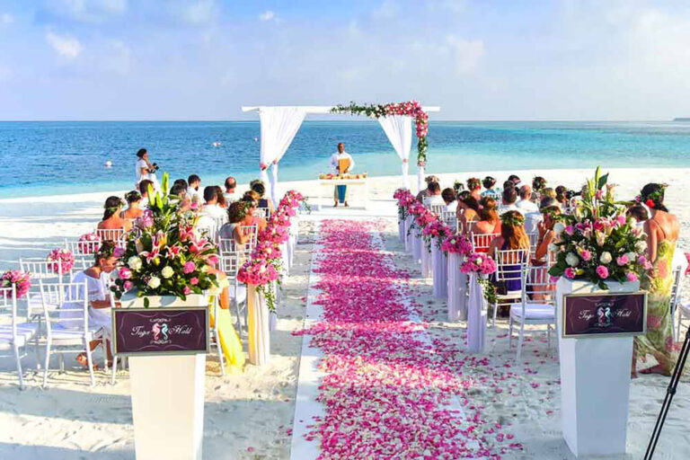 guests seated on chairs at a beach wedding ceremony