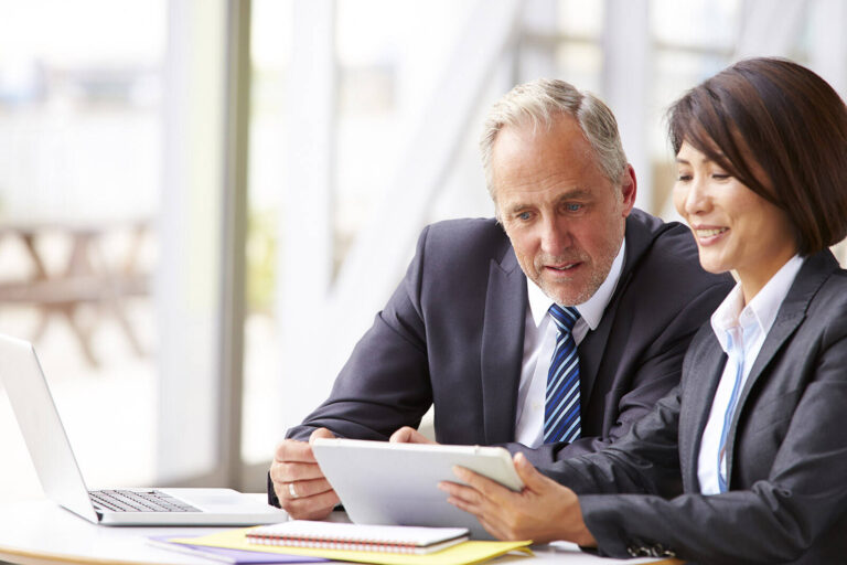 corporate event planner presenting information to a client on a tablet