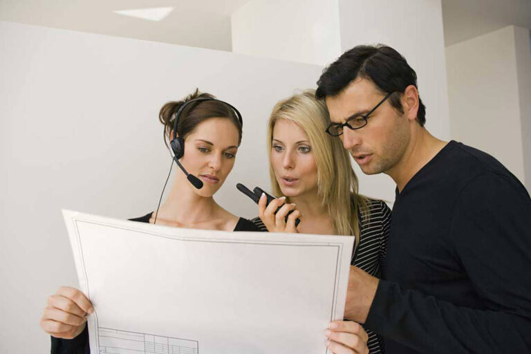 team of event coordinators with walkie talkies discussing floor plans