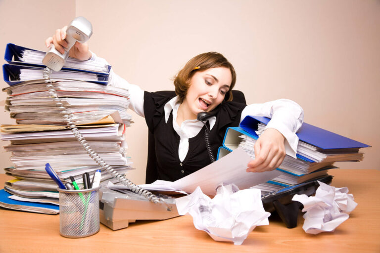 event planner on telephone with a stack of files and folders