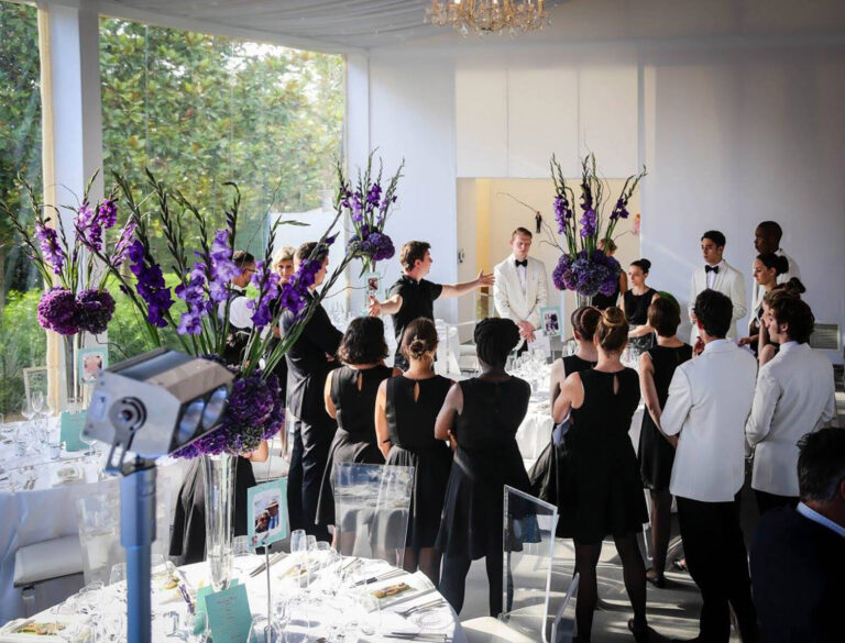 special event catering staff getting a team briefing in a dining room in a tent
