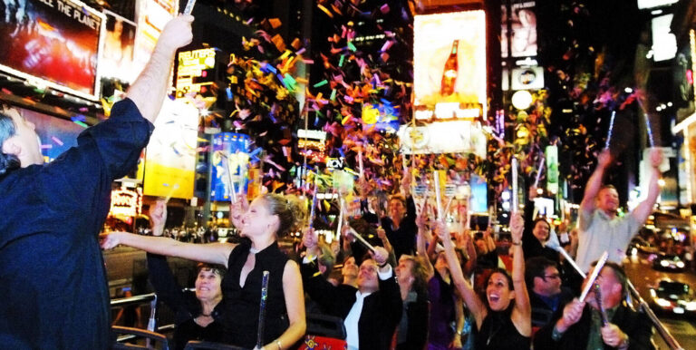 people on a tour bus in New York at night passing through Times Square