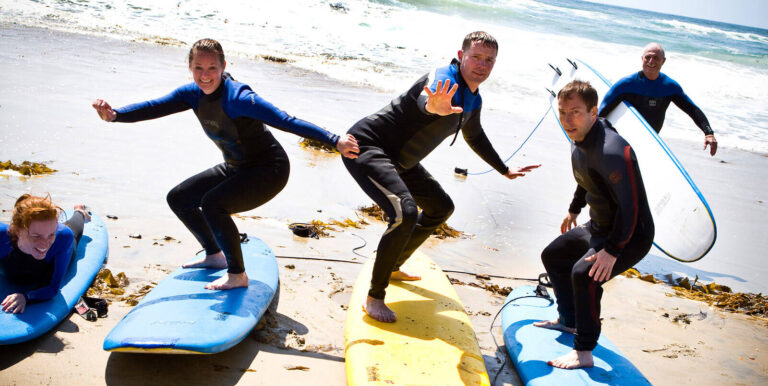 people standing on surfboards at a group surfing class