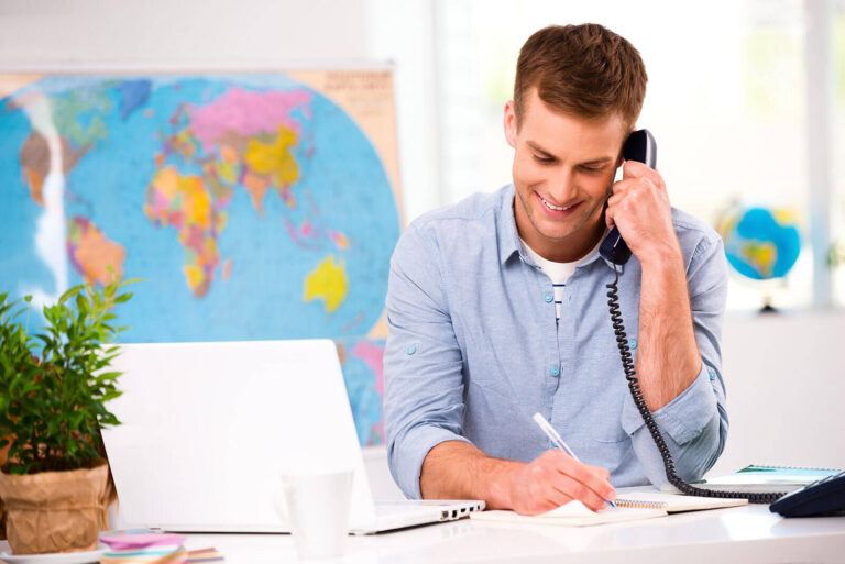 man on phone in an office planning travel