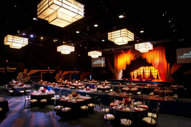 dinner tables and stage set up for an awards ceremony