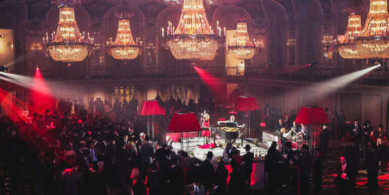 chandeliers over dinner tables and a stage at a corporate event