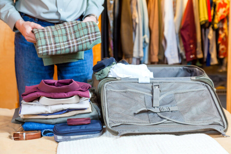packing clothes into a small suitcase