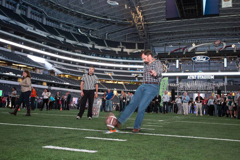 man kicking a football at a private event in a football stadium by Eric Priddy for ACCESS Destination Services.