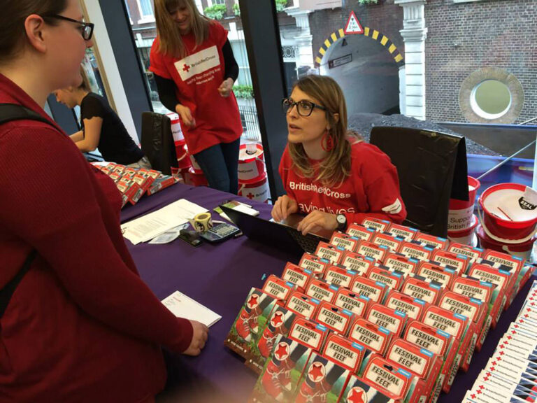 staff at registration desks at The Red Shoe Walk fundraising event for The British Red Cross