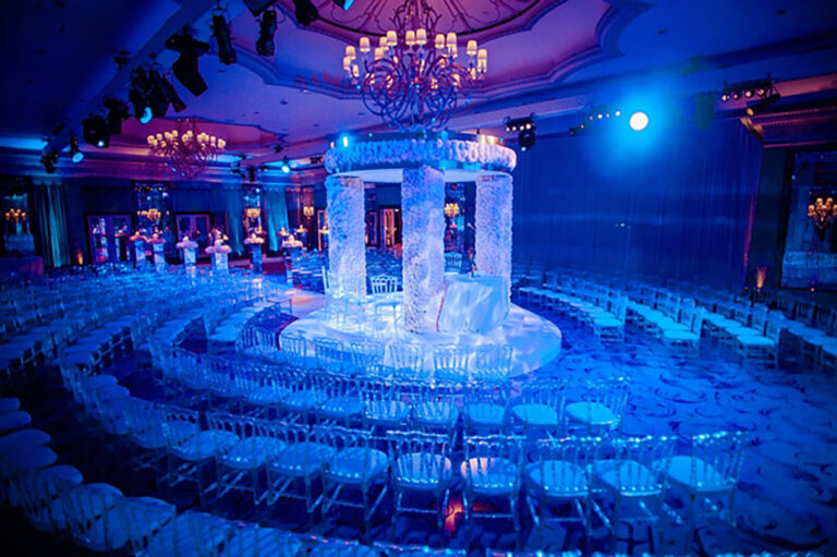 Canopy and chairs bathed in blue light in the ballroom of The Dorchester Hotel set up for a wedding ceremony