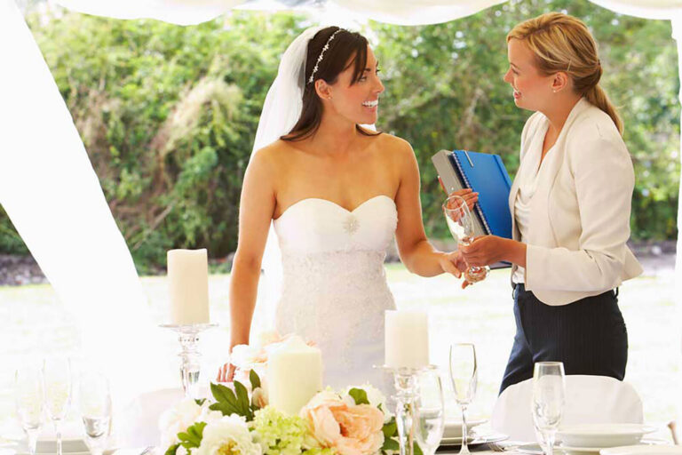 wedding planner discussing glasses with bride at wedding table in a tent