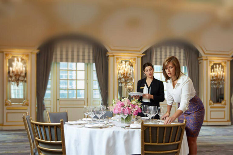Wedding planner and hotel event coordinator setting up a dinner table for an event at St Regis Hotel, New York
