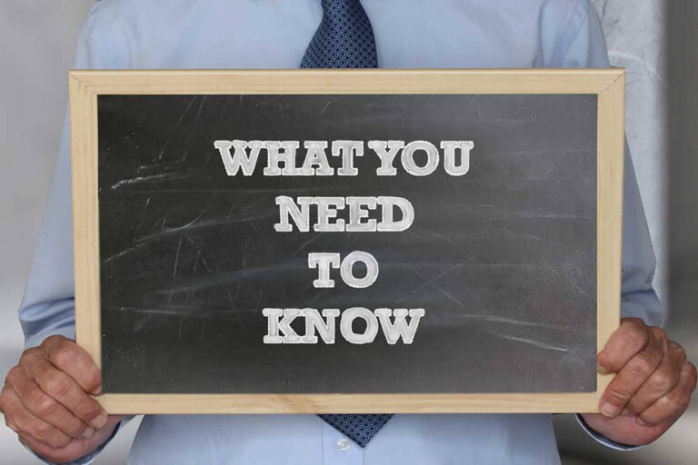 hands holding up a chalkboard sign that reads 'What You Need to Know'