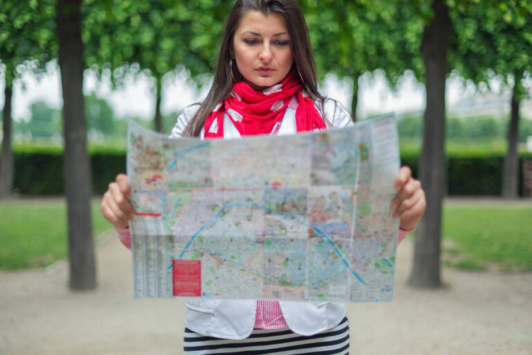 woman standing reading a map outdoors