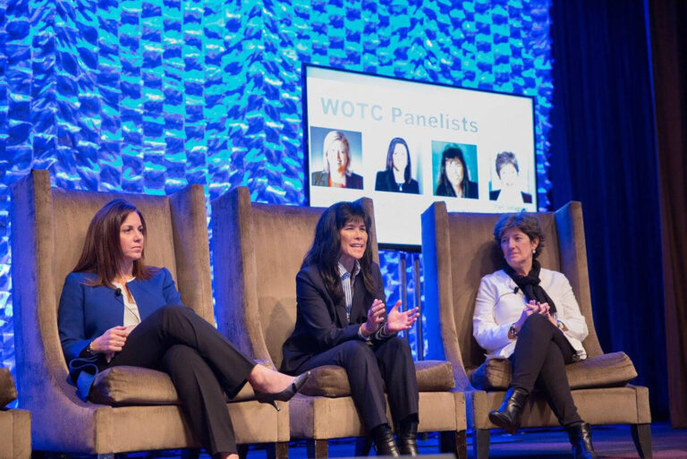 Speakers sitting in chairs on stage during panel discussion at the Women of the Channel Leadership Summit conference
